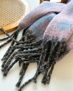 Close-up of pink and grey plaid cashmere-like scarf texture with long black fringe tassels