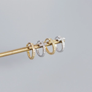 Close-up of S925 sterling silver cross hoop earrings with cubic zirconia in gold and silver