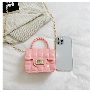 Pink quilted jelly bag with gold chain strap shown with smartphone for size reference