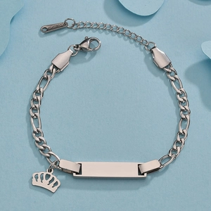 Detail of stainless steel Figaro chain bracelet with crown charm and engravable ID plate