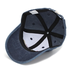 Detail view of the 100% cotton wash label and inner stitching on the blue baseball cap