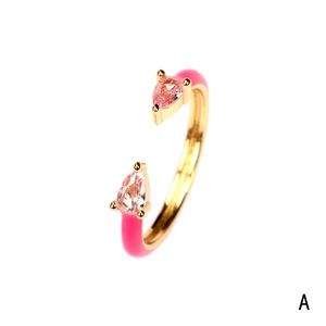 Detailed shot of golden ring with pink enamel ends and pear-shaped pink stones