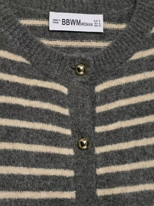 Detailed macro view of striped knit cardigan with textured fabric and gold ball buttons