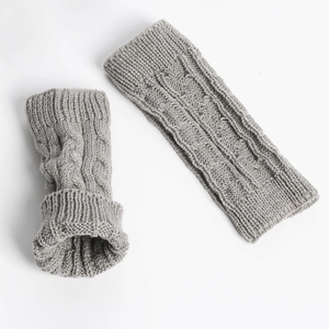 Close-up of grey cable-knit texture on acrylic fingerless arm warmers in flat lay