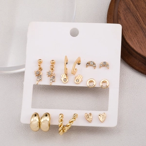 Set of 8 pairs of gold earrings featuring stars, lightning, and heart shapes with rhinestones