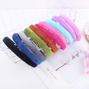 Set of 10 colorful plush fabric headbands for women displayed in a white wire basket