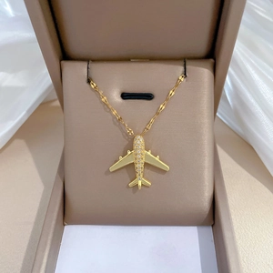 Luxury gold airplane necklace with sparkling crystal inlay on elegant white silk background