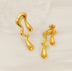 Detail showing irregular wavy gold stud earrings with a glossy liquid metal finish
