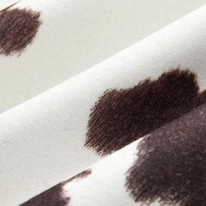 Macro shot of faux fur fabric with brown cow print and soft velvet texture