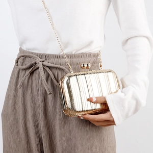 Elegant gold pleated evening clutch bag with metallic shine and a dainty chain strap