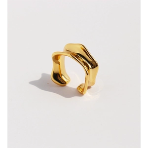 Irregular golden wavy earring with minimalist concave metal design on white background