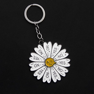 Close-up of daisy decision wheel keychain with spinning Yes No Or petals on black background