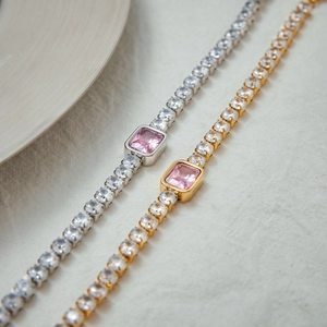 Detail of gold and silver tennis bracelets with rectangle pink zircon gemstones