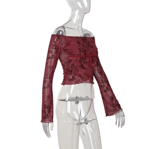 Détail du haut en tulle à épaules dénudées avec imprimé fleuri et nœud en velours
