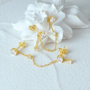 Macro detail of S925 sterling silver chain stud earrings with sparkling cubic zirconia