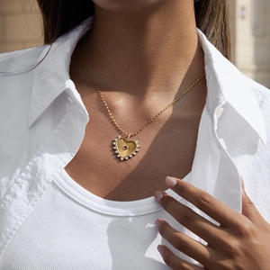 Close-up of 18K gold stainless steel necklace with red heart pendant and small crystals