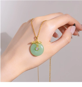Detail of 18K gold-plated necklace with green jade-like stone and zircon pendant