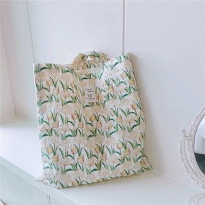Detailaufnahme der Baumwolltasche mit Tulpenprint und Vintage-Spiegel auf weißem Tisch