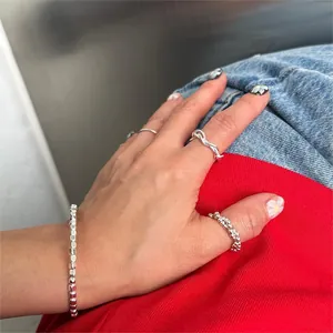 Detailed view of sterling silver chain bracelet and stacked minimalist open rings set