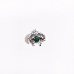 Macro detail of ladybug pendant with silver finish and green crystal inlay