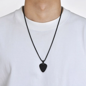 Close-up of a black guitar pick pendant necklace worn by a person on a white T-shirt