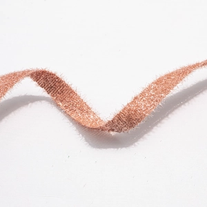 Vue macro d'un ruban à paillettes or rose avec bords à plumes pour décorations festives