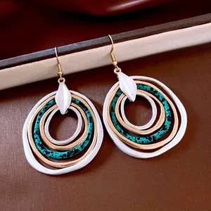 Statement layered circular drop earrings with metallic and teal rings in retro design