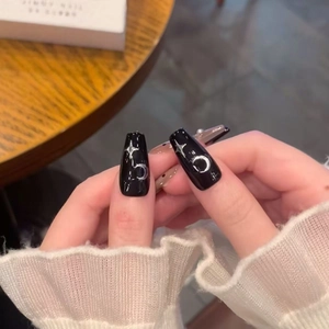 Star and moon patterned black long coffin press-on nails with shiny silver metallic accents