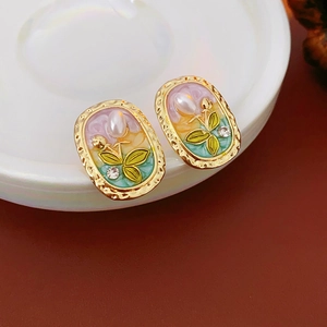 Detailansicht von Vintage Oval-Ohrringen mit Perlen und Diamanten auf weißem Keramikteller
