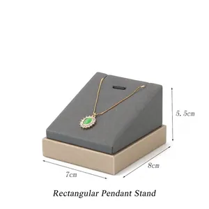 Gray velvet rectangle pendant stand with gold metal base and necklace display detail
