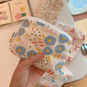Close-up of floral print cotton mini pouches with zipper closure and simple wish label