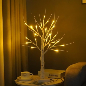 Detail of warm LED birch tree light on a table creating a cozy home atmosphere