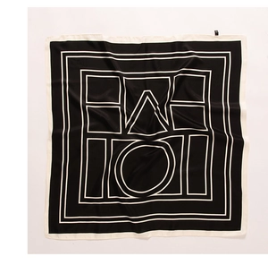 Macro detail of silk-feel square scarf featuring black and white geometric pattern and hem