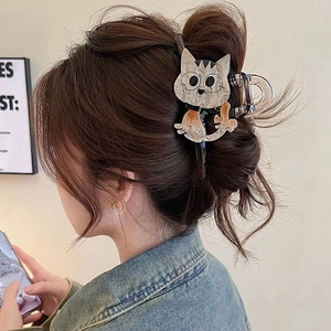 Detail view of a large cute cartoon cat hair claw clip worn on a woman's hair