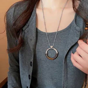 Collana con pendente geometrico ad anello in resina con catena d'argento su un modello