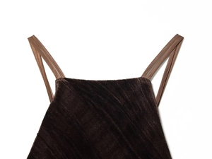 Close-up of brown velvet fabric with glossy texture and slim shoulder straps on the dress