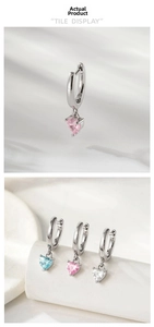 Macro shot of heart-shaped crystal hoop earrings in pink, blue, and white colors