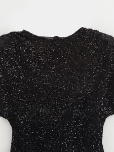 Dettaglio ravvicinato di paillettes nere dense sul tessuto di un abito da sera
