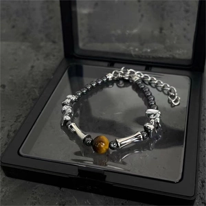 Dettaglio macro del bracciale occhio di tigre e ossidiana con parti metalliche in argento