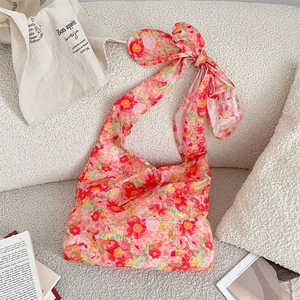 Detailed view of pink floral shoulder bag featuring a large decorative shoulder bow knot
