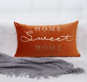 Close-up of orange velvet pillow cover with gold HOME Sweet HOME foil lettering