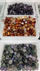 Close-up of assorted heart-shaped natural crystal stones in white display trays