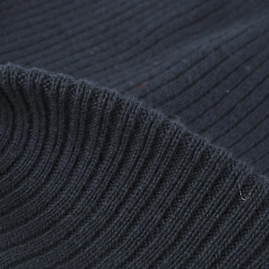 Detail of dark blue rib-knit winter beanie showing thick ribbed fabric texture