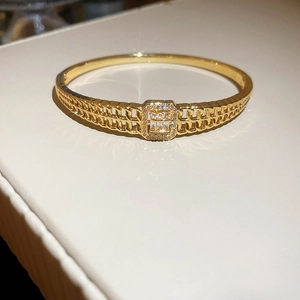 Détail d'un bracelet jonc plaqué or 18K avec chaîne creuse et boucle en zircon