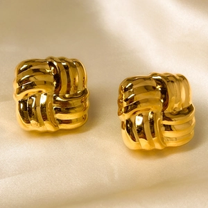 Macro detail of square woven knot earrings in 18K gold plated stainless steel