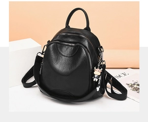 Close-up of black leather backpack featuring multiple zip pockets and hello calf charm