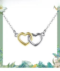Detail of interlocking gold and silver hearts on a minimalist S925 sterling silver chain