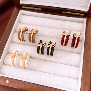 Close-up of vintage bow earrings in cream, coffee, black and burgundy matte finishes