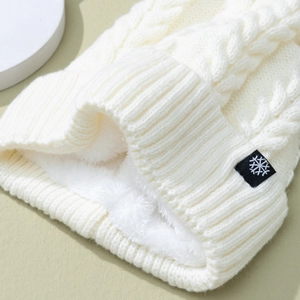 Winter white knit beanie with snowflake patch and cozy fleece lining for warmth