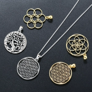 Detailed close-up of gold and silver hollow tree of life and flower of life pendants